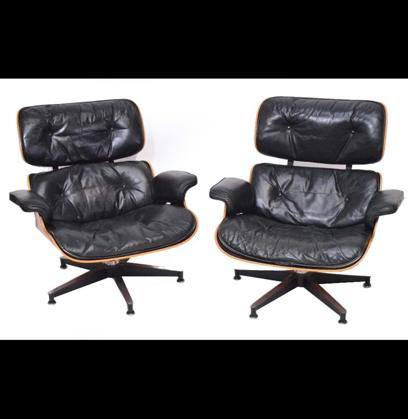 CHARLES AND RAY EAMES FOR HERMAN MILLER; a pair of Charles and Ray Eames for Herman Miller rosewood veneered and black leather upholstered lounge chairs.
